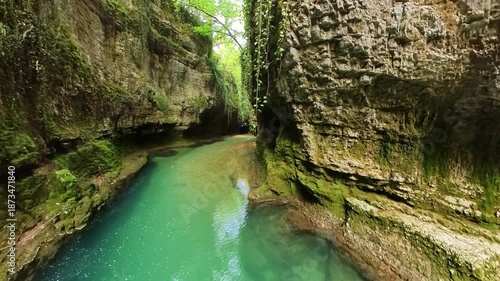boat tour along the calm Abasha River, exploring the stunning natural beauty of Martvili Canyon in Georgia, with its lush green vegetation and moss-covered rock formations