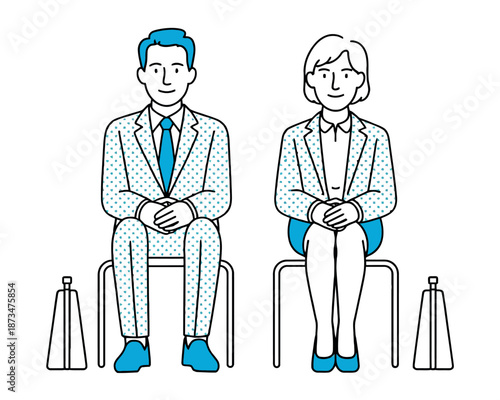 A man and woman in business attire sitting on chairs with social distancing cones