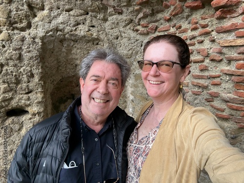 Smiling Couple Poses at a Historic Stone and Brick Wall