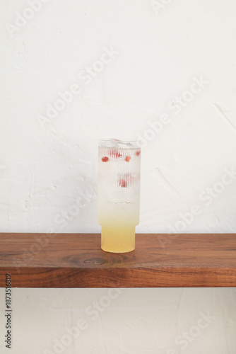 Summer refreshing lemonade iced on wooden table in front of coffee shop. Fresh fruit cold drink.