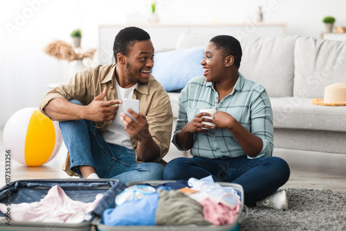 Wallpaper Mural Travel App. African American Travelers Using Smartphone With Great Application For Tourists, Booking Tickets Online And Browsing Internet Sitting Indoors. Spouses Reading Tourism News On Phone Torontodigital.ca