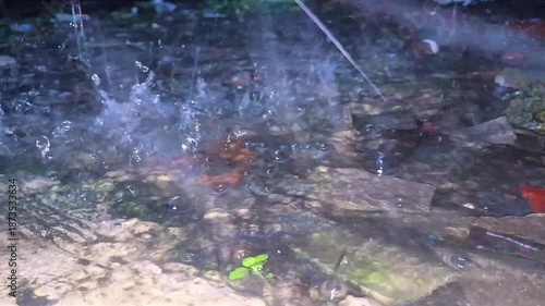 Blurred water surface with splashing droplets and reflective light texture captured in dynamic motion. Abstract background concept