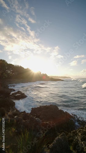Sunset over the ocean with waves crashing against rocky shore at a coastal location. Dominican Republic. Jib shot. 