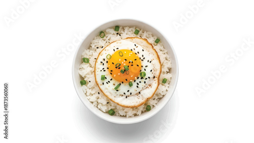 Top-down bowl of steamed rice with a sunny fried egg, black sesame and green scallions on white bowl