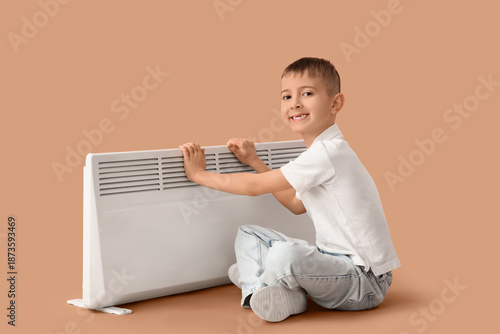 Little boy warming near ele...