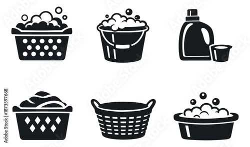Solid glyph laundry icons set featuring baskets, a bucket, detergent bottle, and washing suds for domestic chores