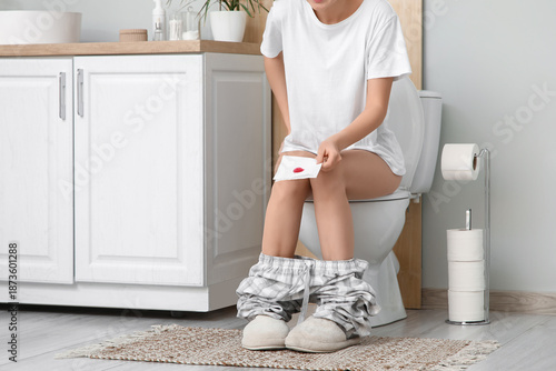 Young woman with hemorrhoid...