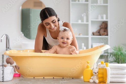 Young mother bathing her li...
