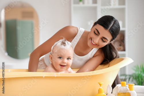 Young mother bathing her ba...