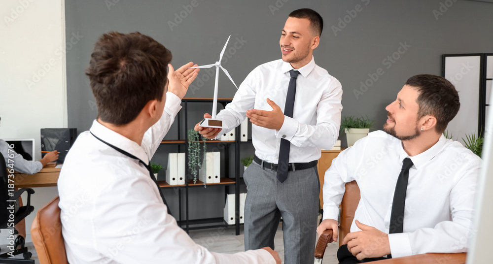 Obraz premium Male engineers working with wind turbine model in office