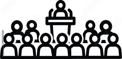 A group of people listening to a speaker at a podium