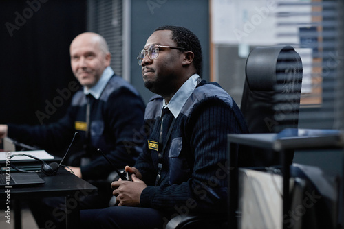 Slika na platnu Middle aged Black man and middle aged Caucasian man working together in security