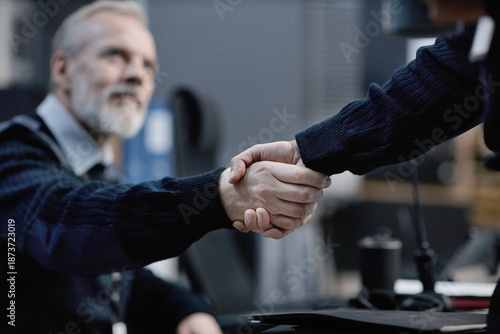 Tableau sur toile Middle aged Caucasian man shaking hands with another in office setting, focusing