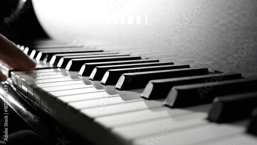 A close-up shot of a person playing the piano, showcasing the keys and the musicians hands in action.