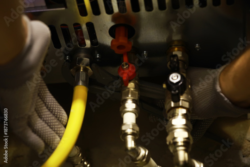 Technician Adjusting Gas Line in Industrial Setting with Safety Gloves
