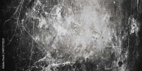 A distressed black and white texture featuring cracks scratches and blurred shapes suggesting age and decay
