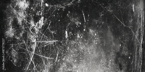 A stark black and white image displaying a heavily textured surface with scratches dust and subtle light variations