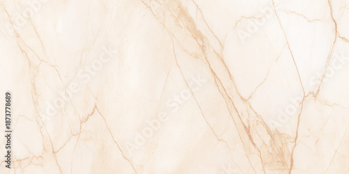A close up view of a beige and gold marbled stone texture showcasing natural veining patterns and subtle color variations