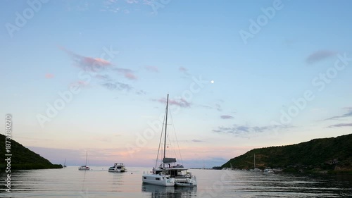 catamaran moored in small cove in Virgin Gorda at sunset with full moon