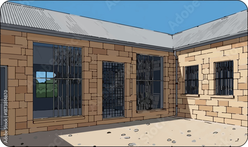 Corner of an old stone building with barred windows and a corrugated roof