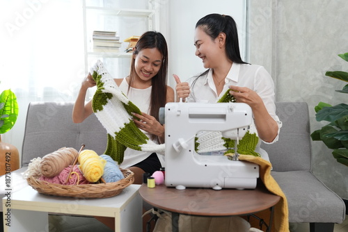 Mother and daughter sew and knit together, teaching the daughter to sew in the living room