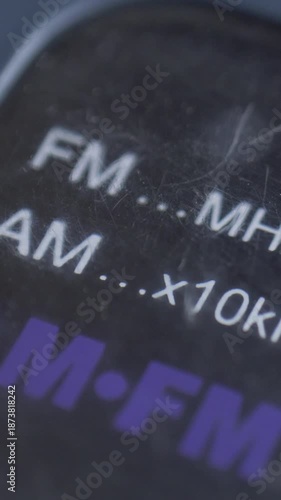 Old radio panel displays FM and AM frequency range in megahertz and kilohertz. Idea of forgotten media. Nostalgia of simpler times. Focus on tactile interface and manual control