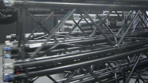 Workers carry metal frame carcass for stage maintaining in concert hall closeup. Employees assemble concert equipment at festival location