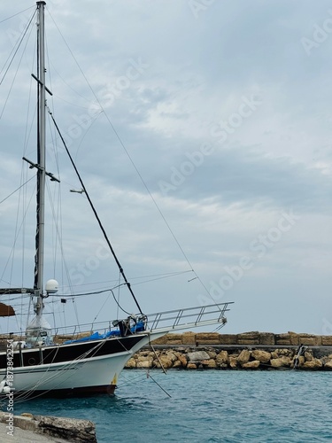 A sleek yacht docked at Kyrenia Waterfront, Cyprus, reflecting on the calm harbor waters under a clear sky