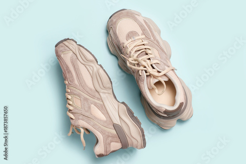 Pair of stylish sneakers on blue background close-up top view