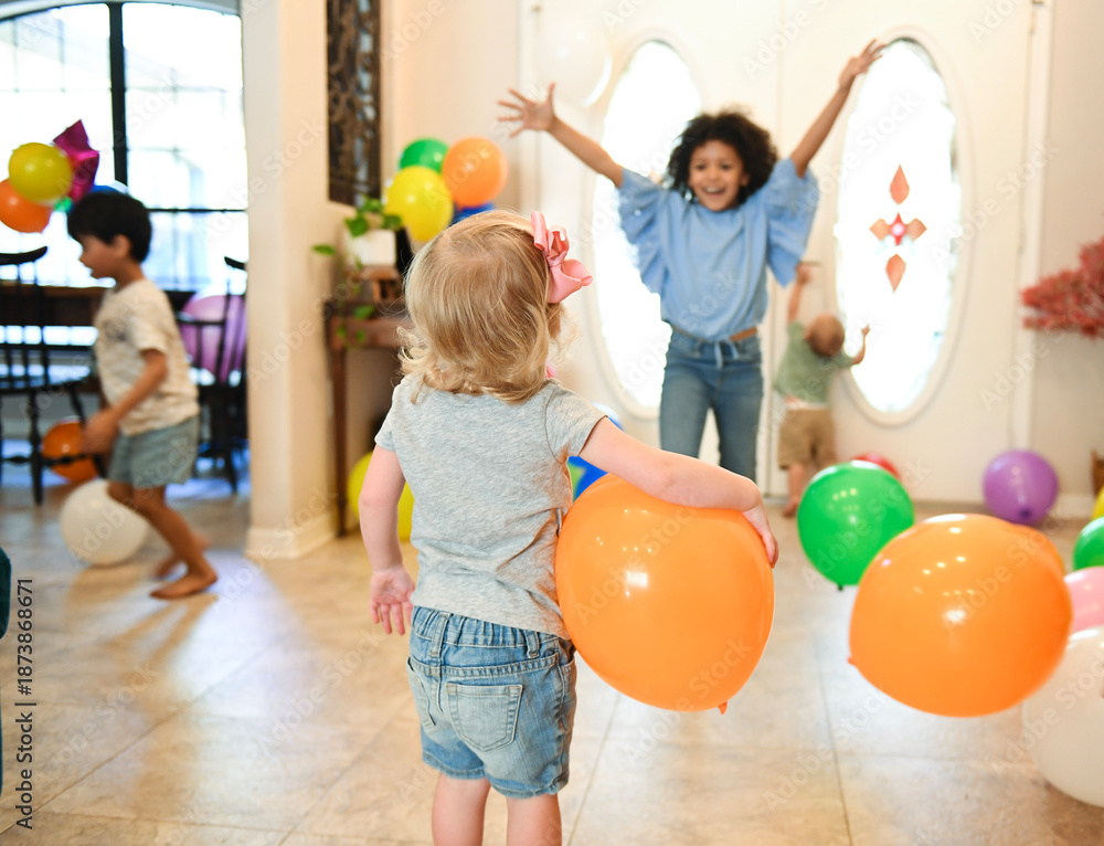 Fototapeta premium Children celebrating indoors with balloons and joyful energy.