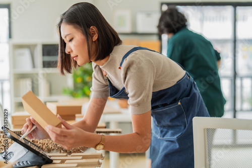 Professional Asian business team collaborates on sustainable eco-friendly packaging and green innovation in a modern office, showcasing leadership, SME growth, and corporate success