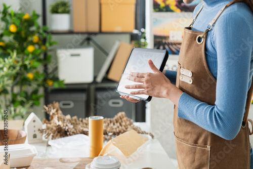 Asian entrepreneurs team in sustainable workshop discussing eco-friendly biodegradable packaging, holding molded pulp trays and kraft boxes,creative green business startup collaboration bright room
