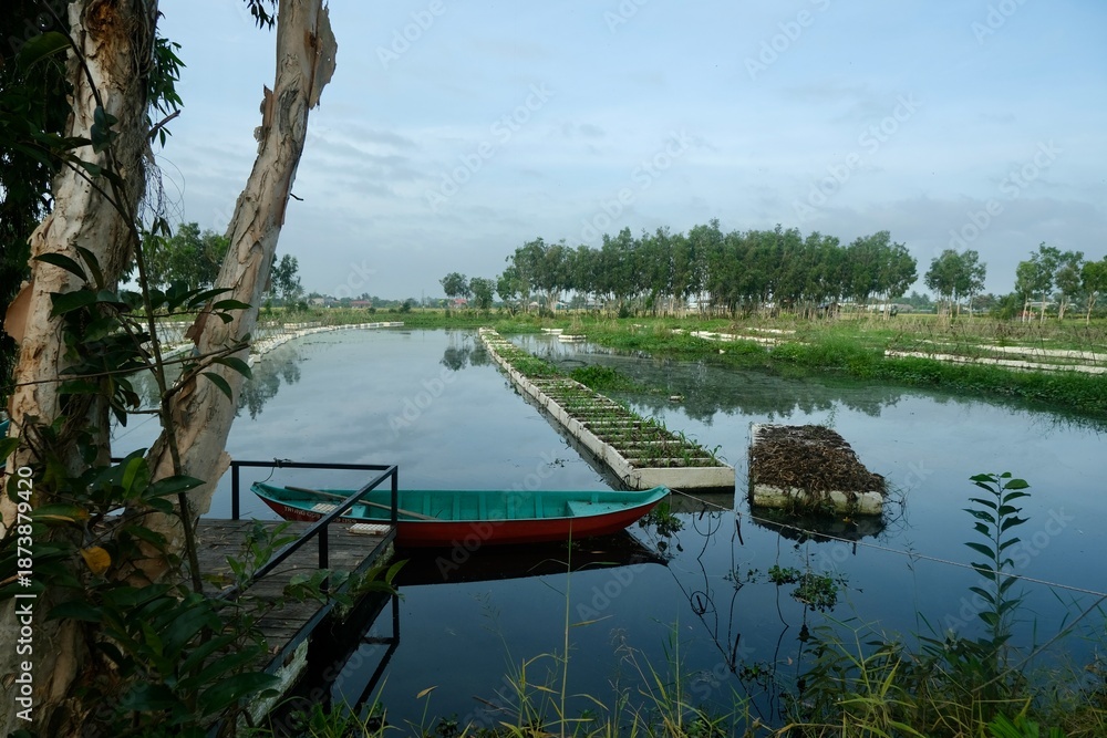 Obraz premium Moored turquoise boat floating vegetable garden rafts Vietnam mangroves river