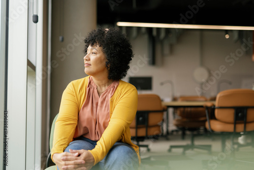 Office worker sitting by a window looking contemplative