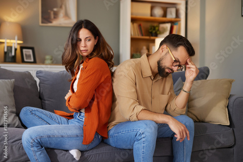 Foto A couple sits back-to-back on a couch, showing signs of conflict