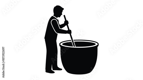 Silhouette of a person stirring a large pot with a long stick