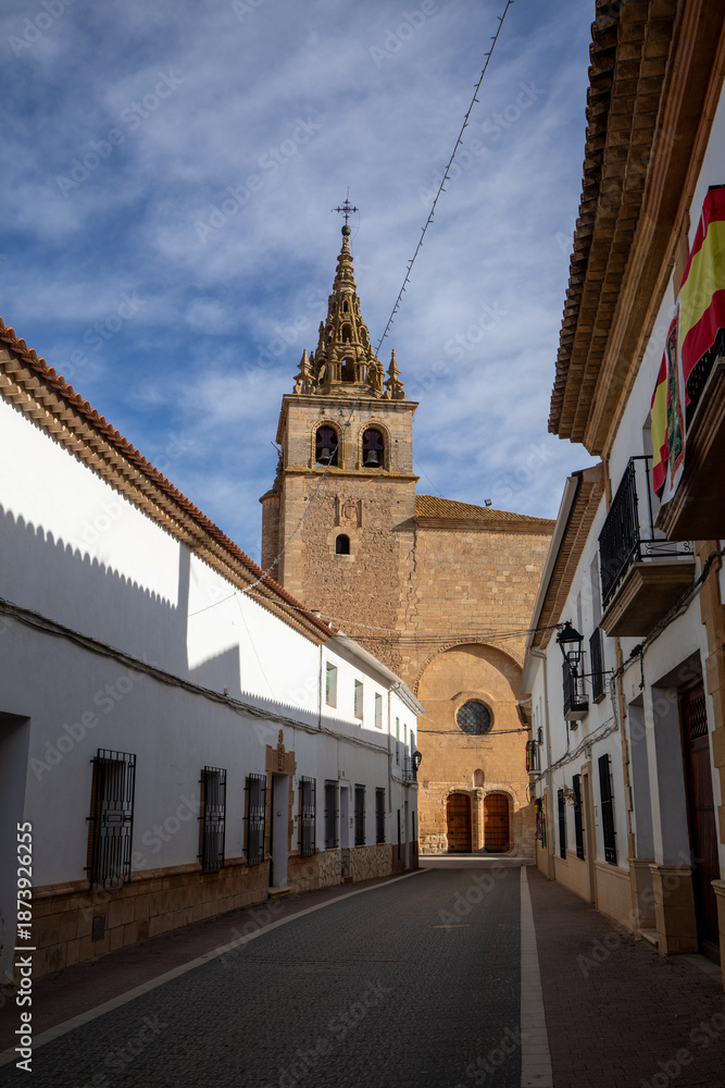 Obraz premium Vertical view of the facade of the Basilica of Our Lady of the Assumption in Villanueva de la Jara, Cuenca, Spain, at the end of a typical village street