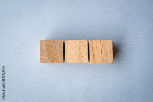 Three blank wooden square blocks in a row
