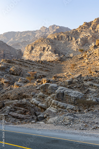 Mountain road background with a stunning view of Jebel Jais under a cloudy sky, a beautiful travel destination in Ras Al Khaimah.