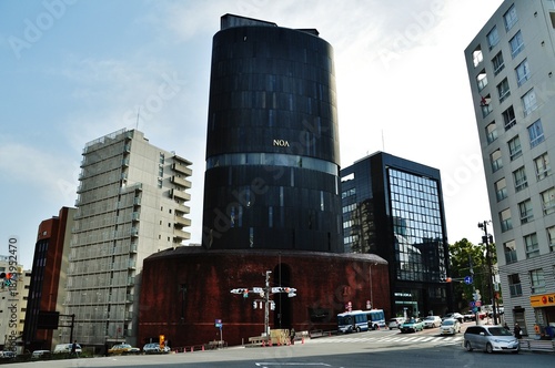Traffic at Iikura Katamachi intersection with NOA Building, Tokyo, Japan