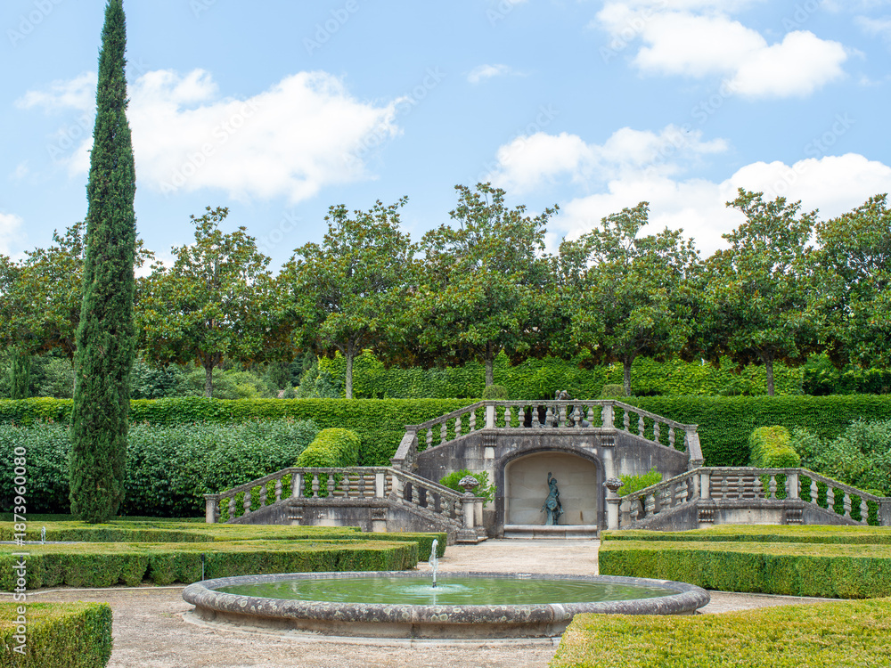 Fototapeta premium A beautiful French garden features a circular fountain in the middle