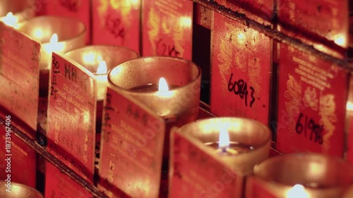 selective focus of Candles for worship lit in a buddhist temple at Jakarta's Chinatown area. translations: protected by the Almighty