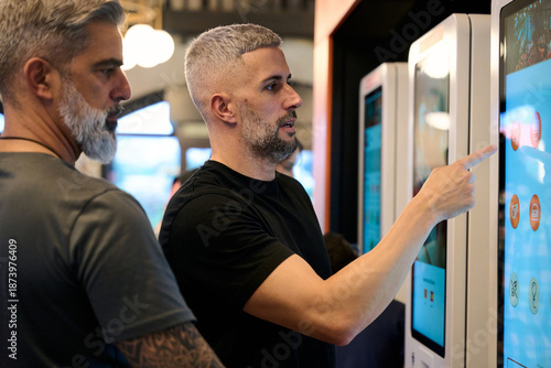 Obraz na plátně Men ordering fast food using self service kiosk