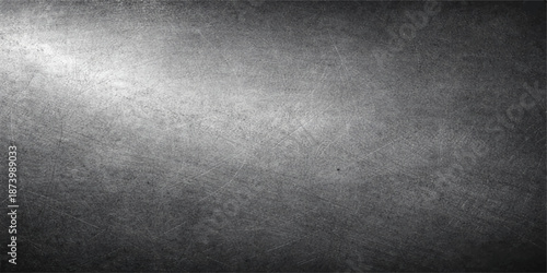 Aged dark brushed metal plate with a vintage grunge texture on a rough grey concrete wall surface backdrop