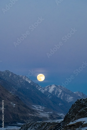 Full moon in the mountains. A beautiful large full moon rose above a mountain peak