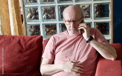 Worried senior man calling doctor feeling stomach pain