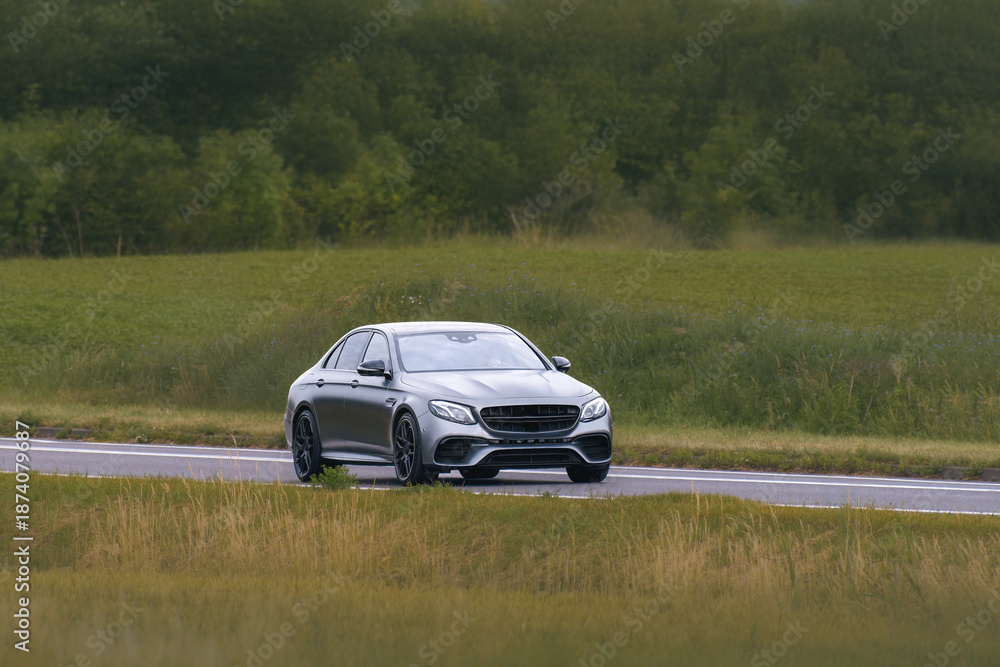 Fototapeta premium Executive sedan driving along scenic highway