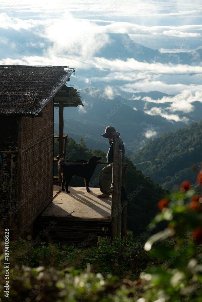 Naklejka premium Simple mountain cabin with a traveler and dog overlooking a sea of clouds