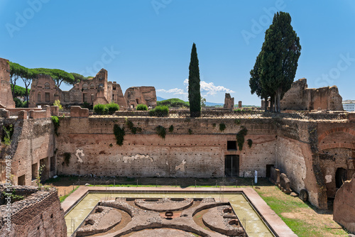 Foto Italy - Rome - Domus Augustana - Ancient Roman palace courtyard with a pool, cypress trees, and brick ruins on the Palatine Hill site