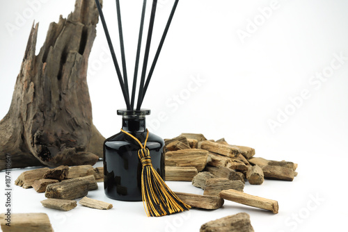 luxury aroma scented reed diffuser glass bottle with black sticks on white table with oud wood or agarwood in nice living room which can create cozy relax aroma ambient scent in from room freshener